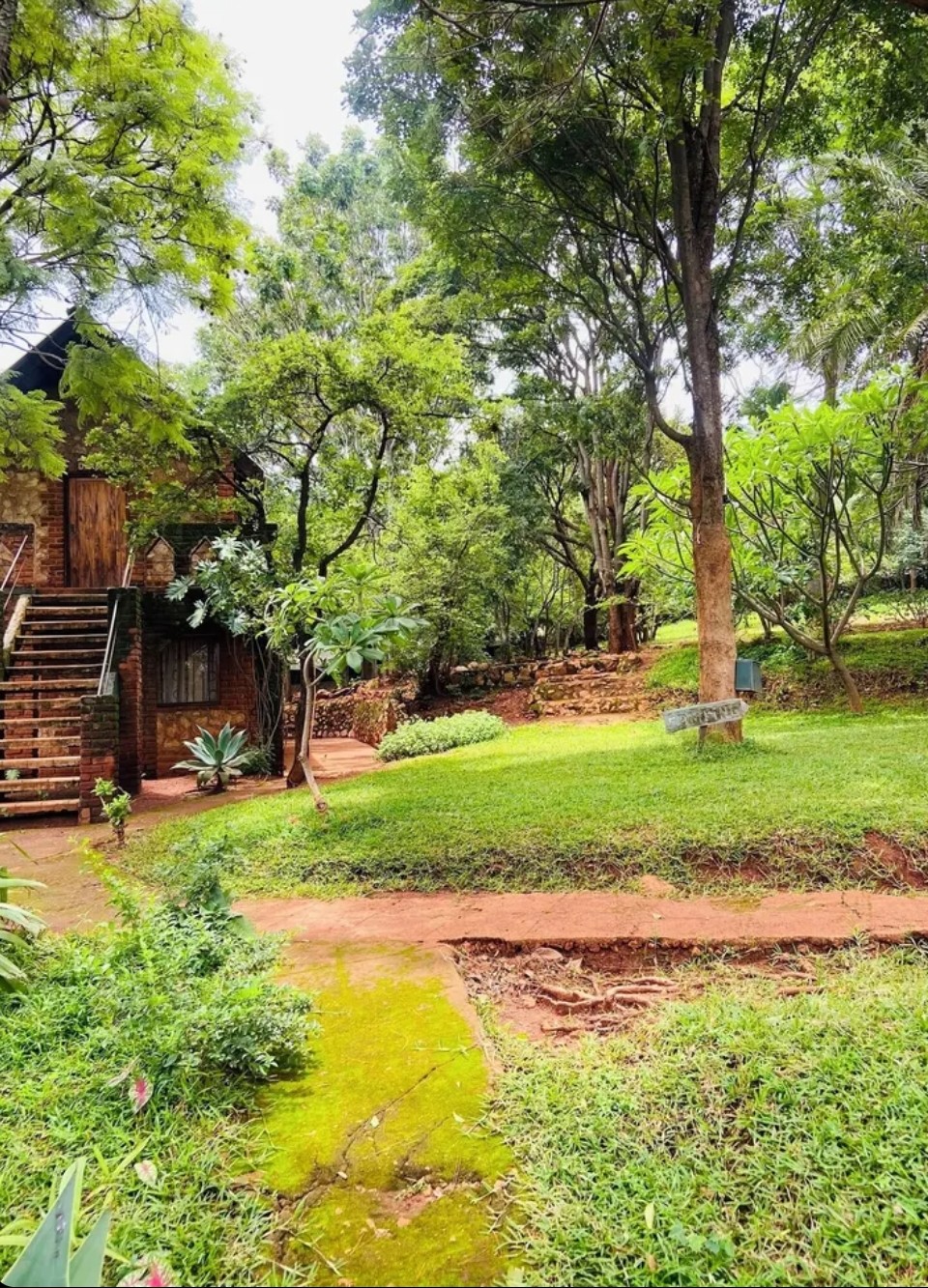 Brick chalet and lush garden pathways at Deans Hill View Lodge